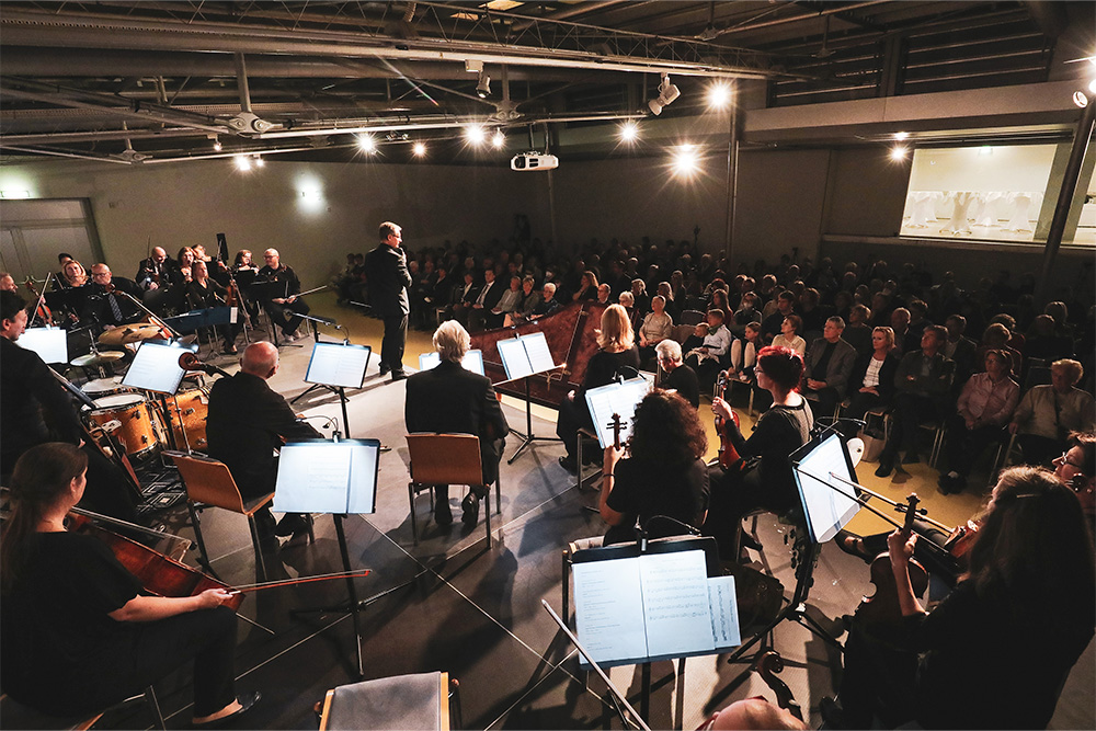 Orchester auf der Bühne mit Blick ins Publikum in der Kunsthalle Leoben