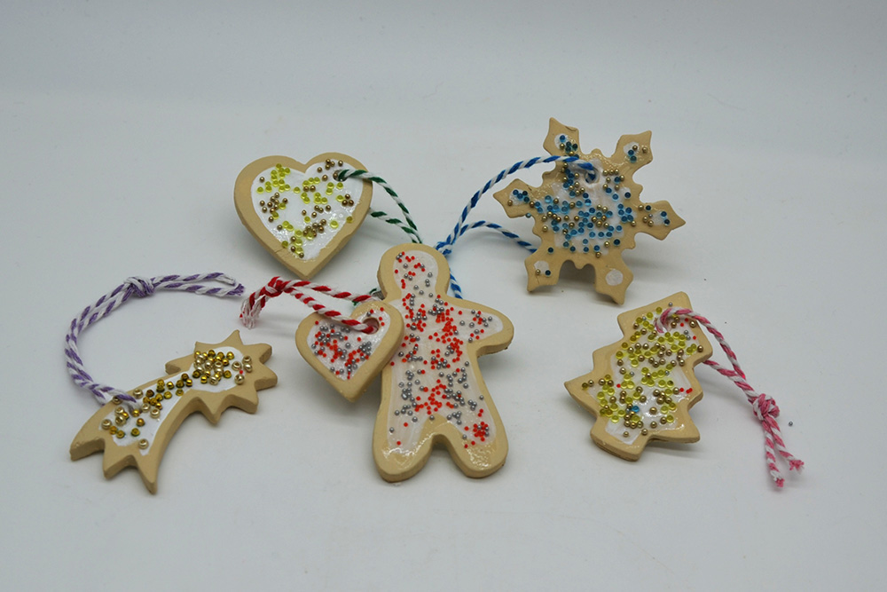 Christbaumanhänger, die mit Keksformen ausgestochen und verziert wurden