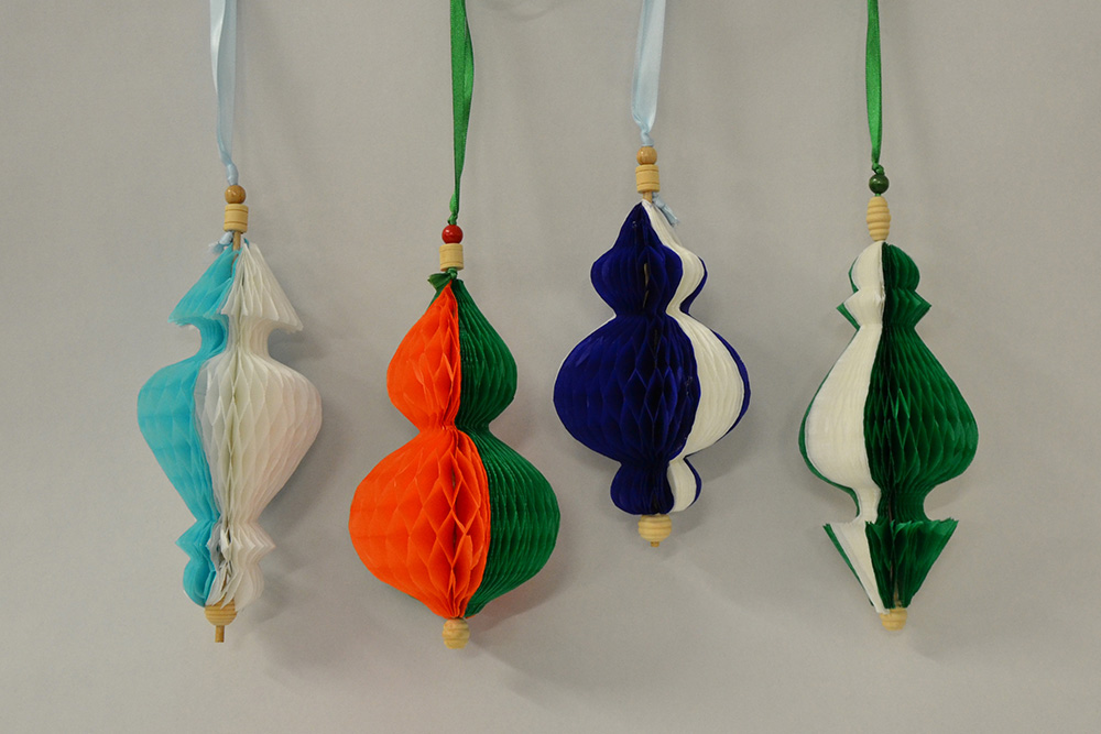 Kunstvoller Papierschmuck: vier gebastelte bunte Lampions mit Bändchen zum Aufhängen
