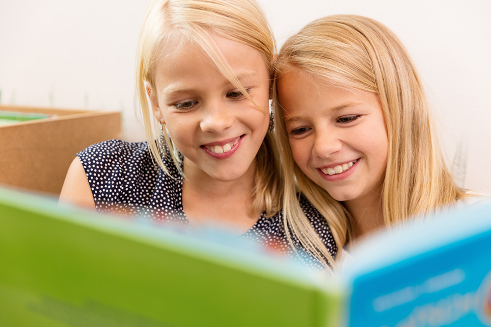 Zwei Kinder lesen in einem Buch